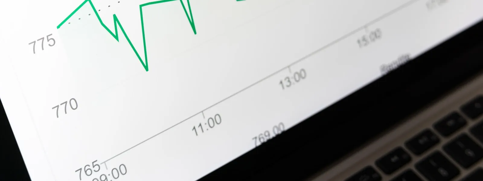 Green securities chart on a laptop screen — applying for an LEI number for an investment fund
